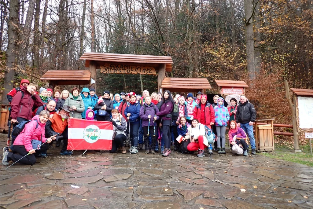 Turyści PTTK Sanok z flagą przy wejściu do rezerwatu przyrody Skamieniale Miasto – atrakcje turystyczne Podkarpacia